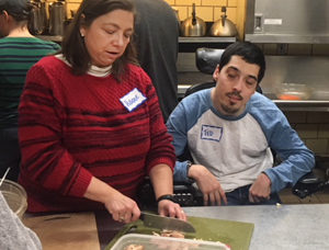 two individuals preparing food at a soup kitchen