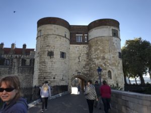 Tower of London in front of a clear blue sky with a tree to the right.