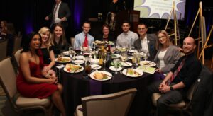 A group of SPARK attendees smile around a table at SPARK