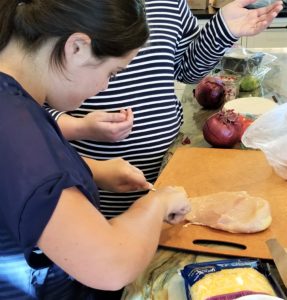 New Skills Inventory client practices her kitchen skills as a tutor is teaching life skills to adults.