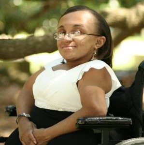 Vilissa Thompson in a white and black dress with her wheelchair.