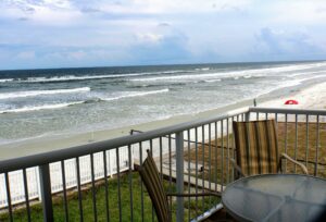 Florida house view over the ocean with deck railing in frame