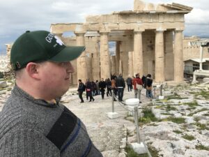 Jonathan stands in front of ancient ruins in Greece as part of his "Create Your Journey" trip