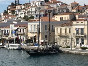 A photo of a boat in Athens with a background of multi-colored buildings in the background.