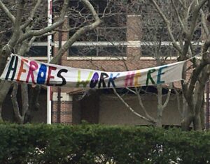 A sign hung from trees reads "Heroes Work Here" outside an Evanston hospital.