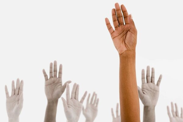 Hands raised in the air against a white background.