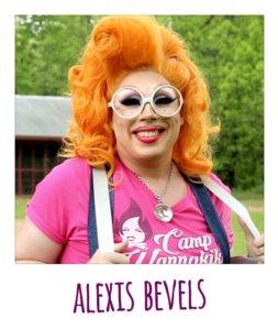 Person in orange wig and pink shirt with suspenders and underneath reads Alexis Bevels