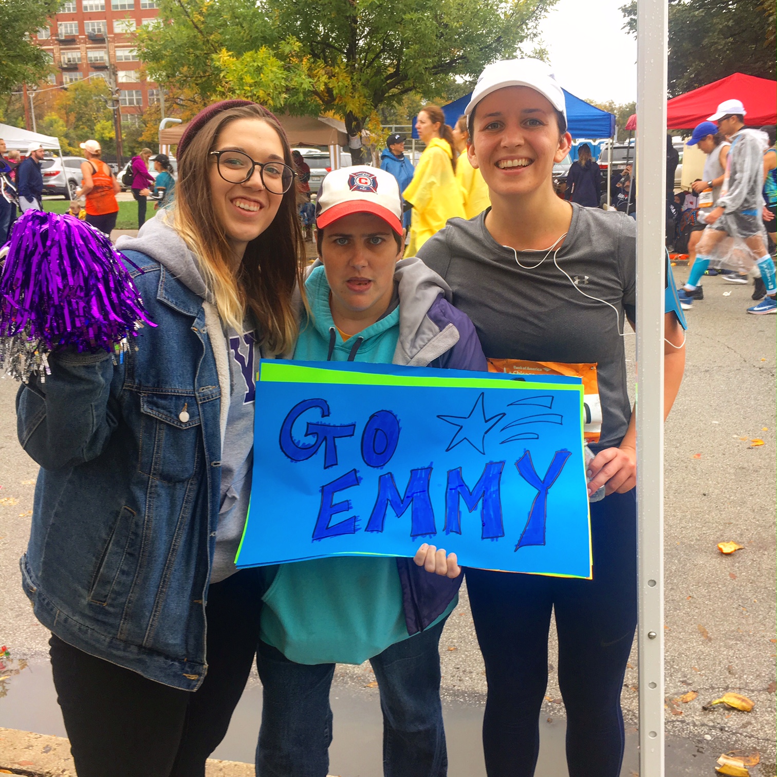 A runner, a participant, and a supporter pose on the Chicago Marathon course